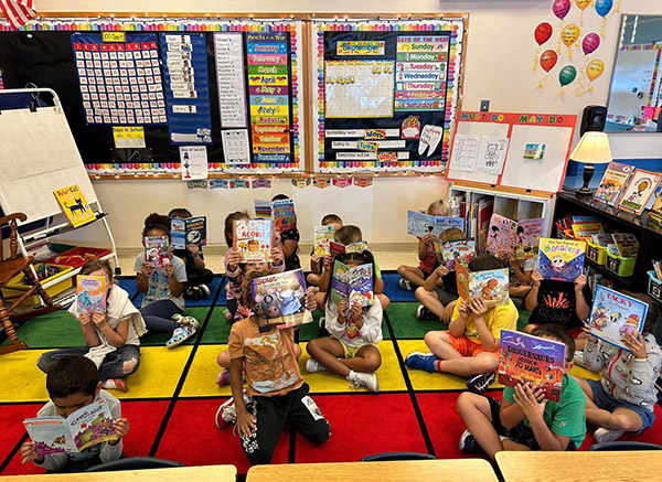 Students sitting down and showing their books